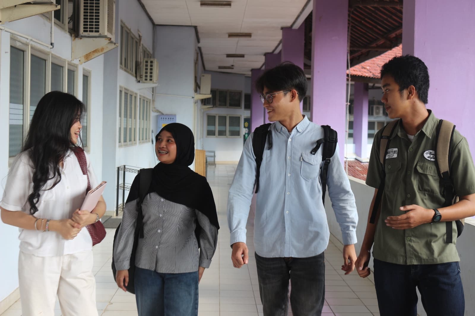 Mahasiswa berdiskusi saat berjalan di koridor departemen